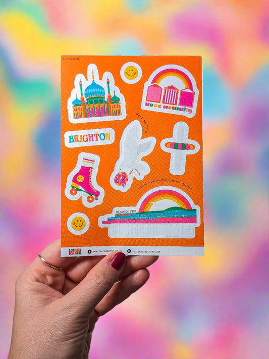 a hand holding a colourful sticker sheet